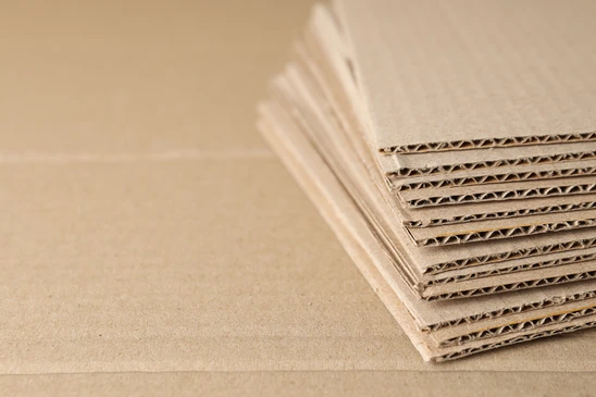 Emballages en carton kraft empilés sur surface beige, matériaux d'expédition pour commerce électronique et logistique